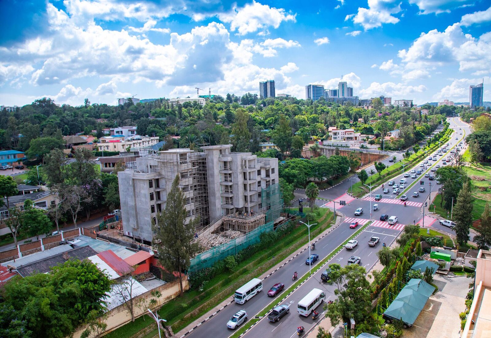 A street in Kigali, Rwanda — traffic and greenery below, the city skyline in the distance